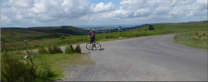 Cyclist stopped to admire the view down Oak Dale from the car park
