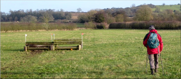 Crossing a field with horse training jumps set up