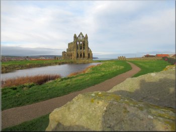 Whitby Abbey seen over the wall by the footway