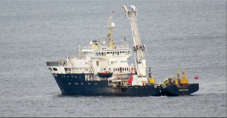 A survey or research vessel anchored off Whitby harbour seen from the Cleveland Way