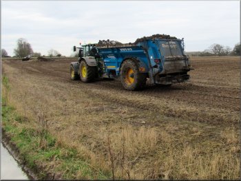 working with an even larger tractor and muck spreader